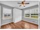 Bedroom features wood floors, two windows and a ceiling fan at 3642 S Bogan Rd, Buford, GA 30519