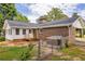 Backyard featuring a brick house, wooden deck, hot tub, fenced-in yard, and greenery at 3642 S Bogan Rd, Buford, GA 30519