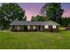 Charming brick home with manicured lawn and lovely curb appeal, complemented by mature trees and an inviting facade at 3642 S Bogan Rd, Buford, GA 30519