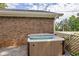 Exterior view of a hot tub with a brick house and greenery in the background at 3642 S Bogan Rd, Buford, GA 30519