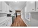 Classic kitchen with white cabinets and laminate countertops, adjoining a living space at 3642 S Bogan Rd, Buford, GA 30519