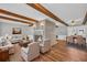Cozy living area featuring a brick fireplace, hardwood floors, and exposed beams, ideal for relaxation and entertaining at 3642 S Bogan Rd, Buford, GA 30519