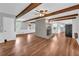 Open living space with central fireplace, wood floors, and exposed beams, perfect for modern living and entertaining at 3642 S Bogan Rd, Buford, GA 30519