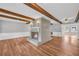 Bright living room with a brick fireplace, beautiful wood floors, and exposed beams, perfect for gatherings at 3642 S Bogan Rd, Buford, GA 30519