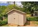 Shed with a double door entrance and surrounded by greenery in the backyard at 3642 S Bogan Rd, Buford, GA 30519