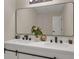 Modern bathroom vanity with double sinks, white countertops, and sleek black fixtures beneath a large, stylish mirror at 589 Wilmont Dr, Jonesboro, GA 30238