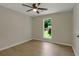 Bright bedroom featuring a large window, ceiling fan, wood-look floors, and neutral walls at 589 Wilmont Dr, Jonesboro, GA 30238