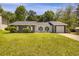 Charming one-story home features a well-maintained lawn, a covered front porch, and a driveway leading to a garage at 589 Wilmont Dr, Jonesboro, GA 30238