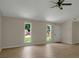 Open-concept living room featuring ample natural light, neutral walls, and wood-look floors, with vaulted ceiling at 589 Wilmont Dr, Jonesboro, GA 30238