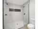 Elegant walk-in shower featuring marble-patterned walls, black hardware, glass door, and convenient built-in niche at 589 Wilmont Dr, Jonesboro, GA 30238