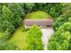 Aerial shot featuring a home, driveway, manicured lawn, and a dense tree line at 100 Eldorado Dr, Carrollton, GA 30116