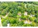 Aerial view showing the house situated in a neighborhood surrounded by lush trees at 100 Eldorado Dr, Carrollton, GA 30116