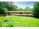 The backyard features a green lawn, mature trees, patio, and the back of the house at 100 Eldorado Dr, Carrollton, GA 30116