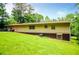 The backyard features a green lawn, mature trees, patio, and the back of the house at 100 Eldorado Dr, Carrollton, GA 30116