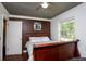 Bedroom with a wooden bed frame, dark brown wall, and a window offering natural light at 100 Eldorado Dr, Carrollton, GA 30116