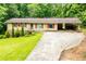 Charming single-story home featuring red accents, attached carport, and a well-maintained front yard at 100 Eldorado Dr, Carrollton, GA 30116