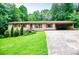 Charming single-story home featuring red accents, attached carport, and a well-maintained front yard at 100 Eldorado Dr, Carrollton, GA 30116