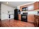 Well lit kitchen featuring wood cabinets, black appliances and ample countertop space at 100 Eldorado Dr, Carrollton, GA 30116