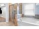 Bathroom featuring a glass shower, soaking tub, and tile surround at 130 Bevington Ln, Woodstock, GA 30188