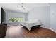 Cozy bedroom with hardwood floors, a ceiling fan, a large window, and light blue walls at 130 Bevington Ln, Woodstock, GA 30188