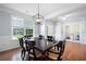 Formal dining room with stylish light fixture, wainscoting detail, and view to the office at 130 Bevington Ln, Woodstock, GA 30188
