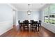 Elegant dining room with hardwood floors, a modern chandelier, and large window overlooking the lawn at 130 Bevington Ln, Woodstock, GA 30188