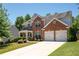 Beautiful two-story brick home with a well-manicured lawn, double garage, and charming curb appeal at 130 Bevington Ln, Woodstock, GA 30188