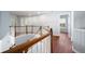 Upper hallway with hardwood floors, a wooden railing and neutral blue colored walls at 130 Bevington Ln, Woodstock, GA 30188
