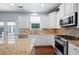 Bright kitchen with white cabinets, stainless steel appliances and granite countertops at 130 Bevington Ln, Woodstock, GA 30188