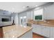 Bright kitchen with white cabinets, a large island, stainless steel appliances and hardwood floors at 130 Bevington Ln, Woodstock, GA 30188
