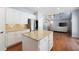 Bright kitchen with white cabinets and a large island flowing into a living room at 130 Bevington Ln, Woodstock, GA 30188
