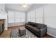 Bright sunroom with a stone fireplace, dark gray sofa and large windows at 130 Bevington Ln, Woodstock, GA 30188