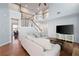 Bright living room featuring hardwood floors, stairs to the second floor, and a large television at 130 Bevington Ln, Woodstock, GA 30188