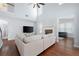 Spacious living room featuring hardwood floors, a ceiling fan, and a stone fireplace at 130 Bevington Ln, Woodstock, GA 30188