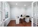 Bright home office featuring hardwood floors, a large window, and a modern desk setup at 130 Bevington Ln, Woodstock, GA 30188