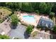 Community pool with lounge chairs, surrounded by lush landscaping, with a playground and parking at 130 Bevington Ln, Woodstock, GA 30188