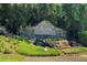 Elegant stone entrance sign for Madison Falls community, enhanced by lush greenery and a waterfall at 130 Bevington Ln, Woodstock, GA 30188