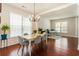 Bright dining room featuring hardwood floors, modern chandelier, and view into the living area at 169 Wallnut Hall Circle, Woodstock, GA 30189