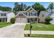 Inviting home featuring manicured lawn, two-car garage, and cozy seating on the front porch at 169 Wallnut Hall Circle, Woodstock, GA 30189