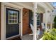 Charming front porch featuring red brick, white pillars, and comfortable Adirondack chairs at 169 Wallnut Hall Circle, Woodstock, GA 30189