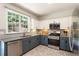 Kitchen with stainless steel appliances, modern backsplash, and patterned tile floor at 169 Wallnut Hall Circle, Woodstock, GA 30189