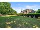 Expansive backyard featuring a well-maintained lawn, mature trees, and lush landscaping around the tan home at 4440 Green Summers Dr, Cumming, GA 30028