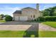 Rear view of the home featuring a two-car garage, concrete driveway, and landscaped yard at 4440 Green Summers Dr, Cumming, GA 30028
