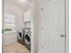 Laundry room with tile flooring, washer, dryer, and window offering natural light at 4440 Green Summers Dr, Cumming, GA 30028