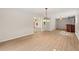 Open-concept living area featuring hardwood floors, an elegant chandelier, and a glimpse of the bar at 4440 Green Summers Dr, Cumming, GA 30028