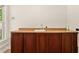 Wet bar featuring wooden cabinets, countertop, sink, and updated fixtures at 4440 Green Summers Dr, Cumming, GA 30028