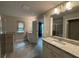 Bright bathroom with a double sink vanity, granite countertops, and tiled shower at 338 Cherryhill Ln, Woodstock, GA 30188