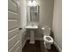 Bathroom featuring a pedestal sink and toilet with dark hardwood flooring at 338 Cherryhill Ln, Woodstock, GA 30188