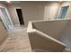 Upstairs hallway with light hardwood-style floors and two doors, one leading to a dark room at 338 Cherryhill Ln, Woodstock, GA 30188