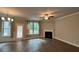 Spacious living room featuring a fireplace, ceiling fan, and large windows for ample natural light at 338 Cherryhill Ln, Woodstock, GA 30188